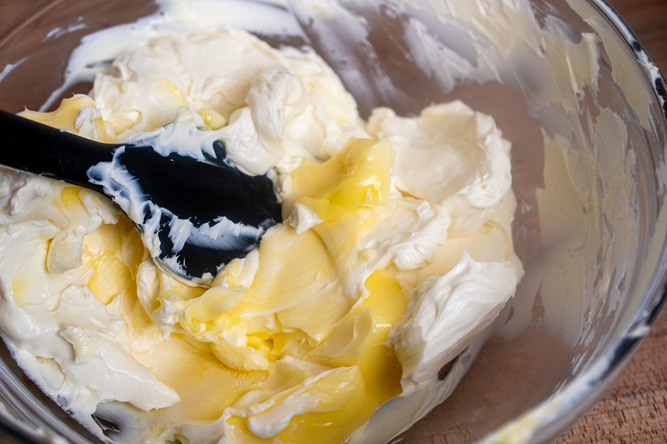 Butter and cream cheese being mixed together to create a smooth and creamy frosting.