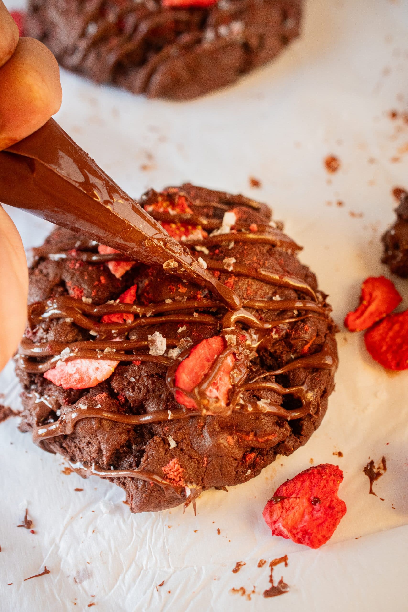 Drizzling melted chocolate over a cookie.
