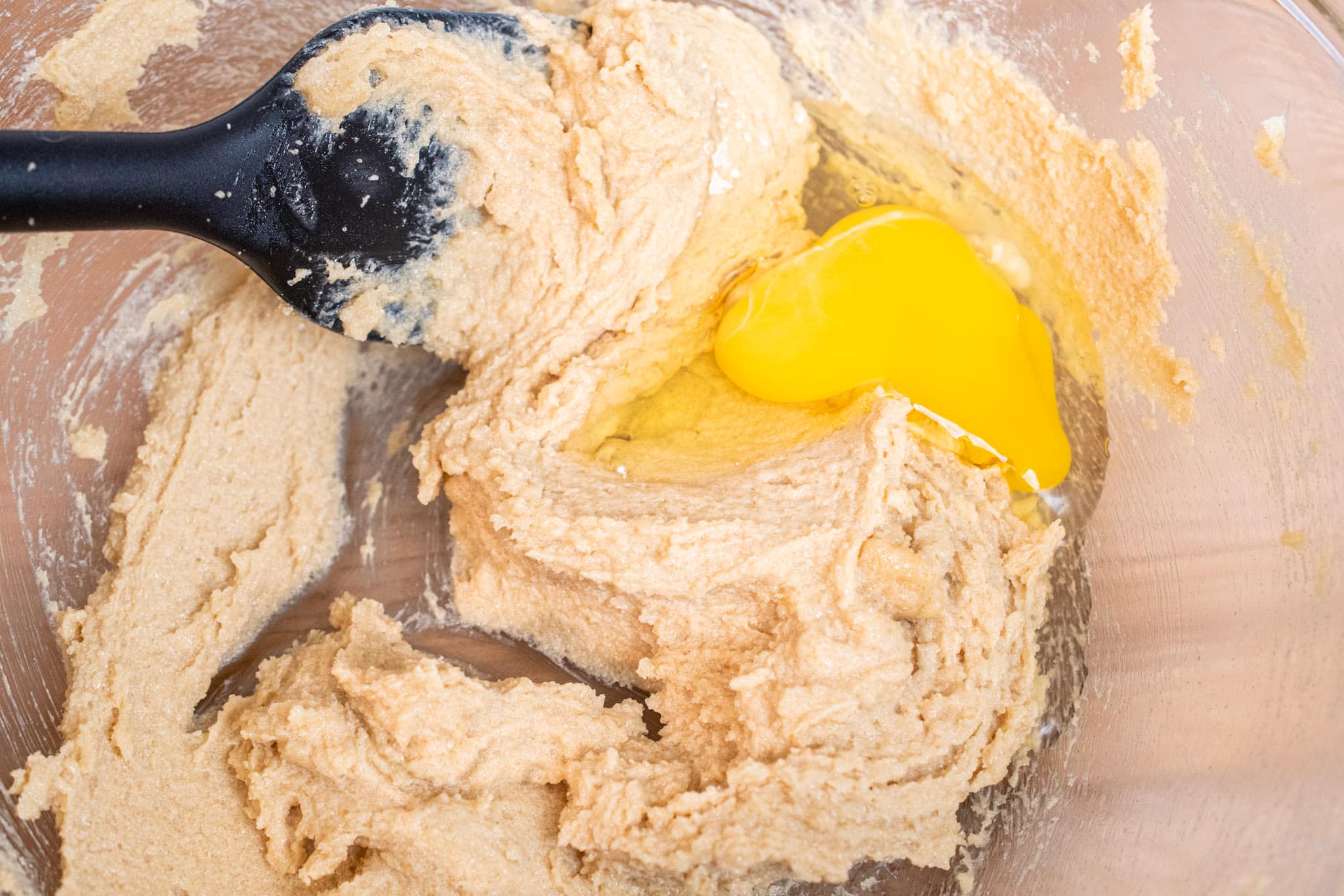 Beating in an egg to the butter and sguar mixture.