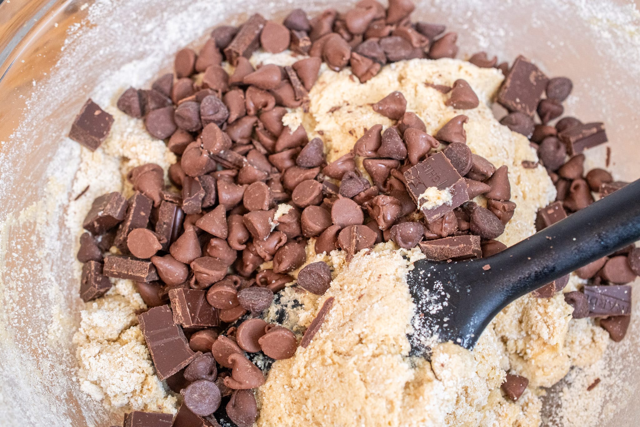 Adding chocolate chips and chopped chocolate to the dough.