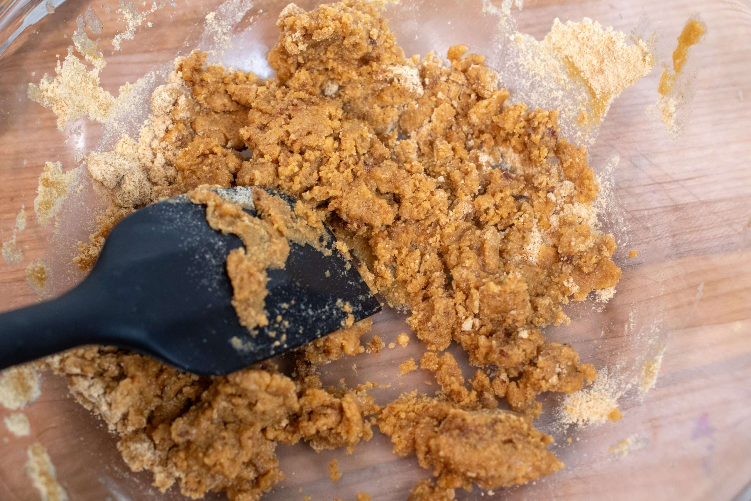 Mixing graham cracker crust mixture with a spatula until combined.