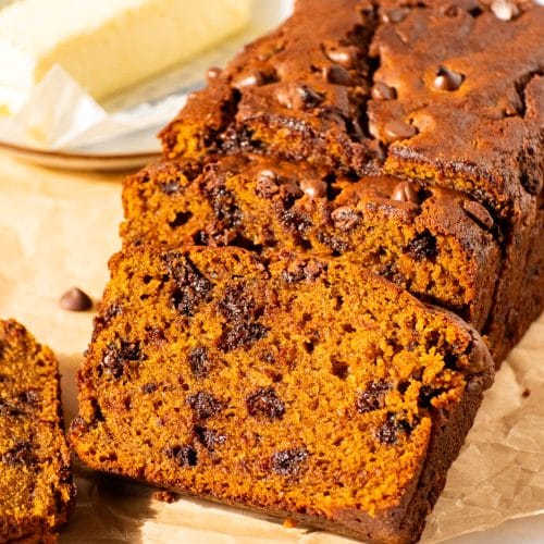 Moist pumpkin chocolate chip bread loaf sliced open to reveal a rich, soft crumb filled with melted chocolate chips.