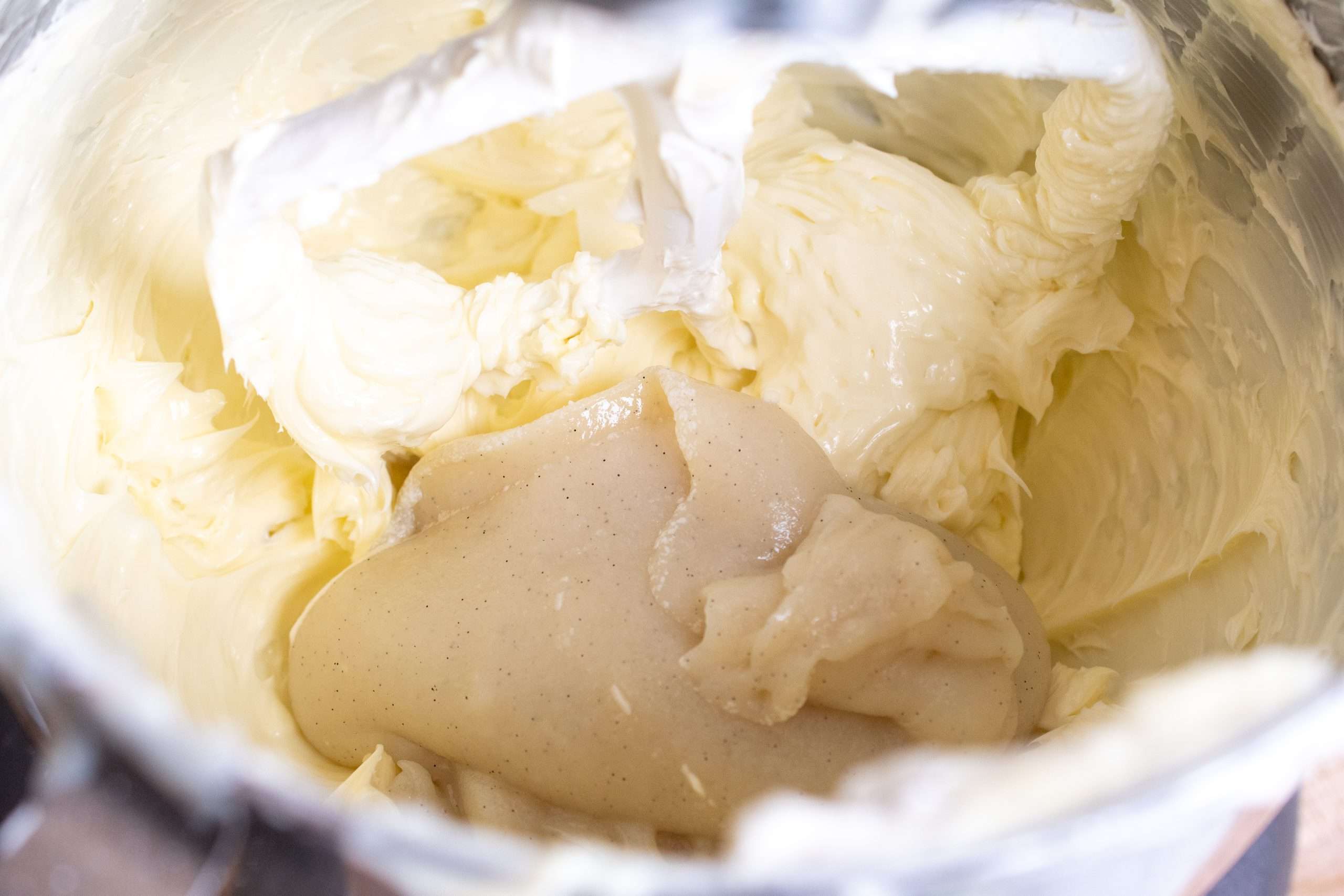 Adding cooked vegan roux to softened vegan butter in a mixing bowl for ermine frosting.