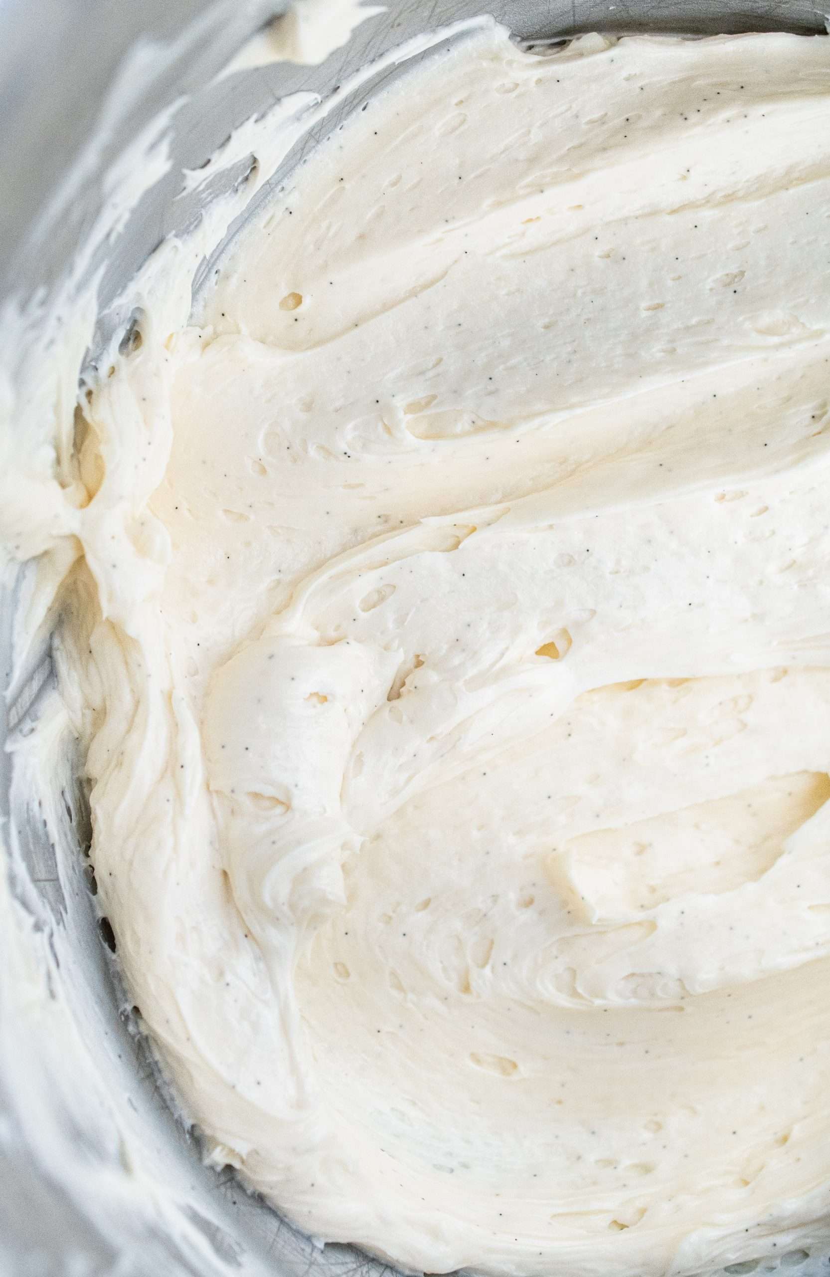 Close-up of whipped vegan buttercream frosting with visible vanilla bean specks.