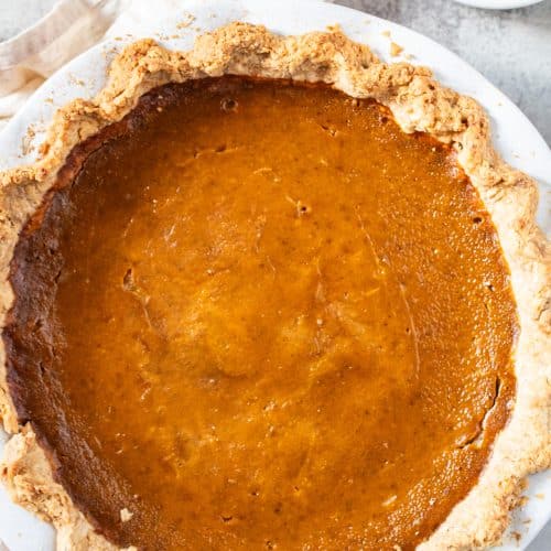 Whole creamy pumpkin pie in a flaky golden crust