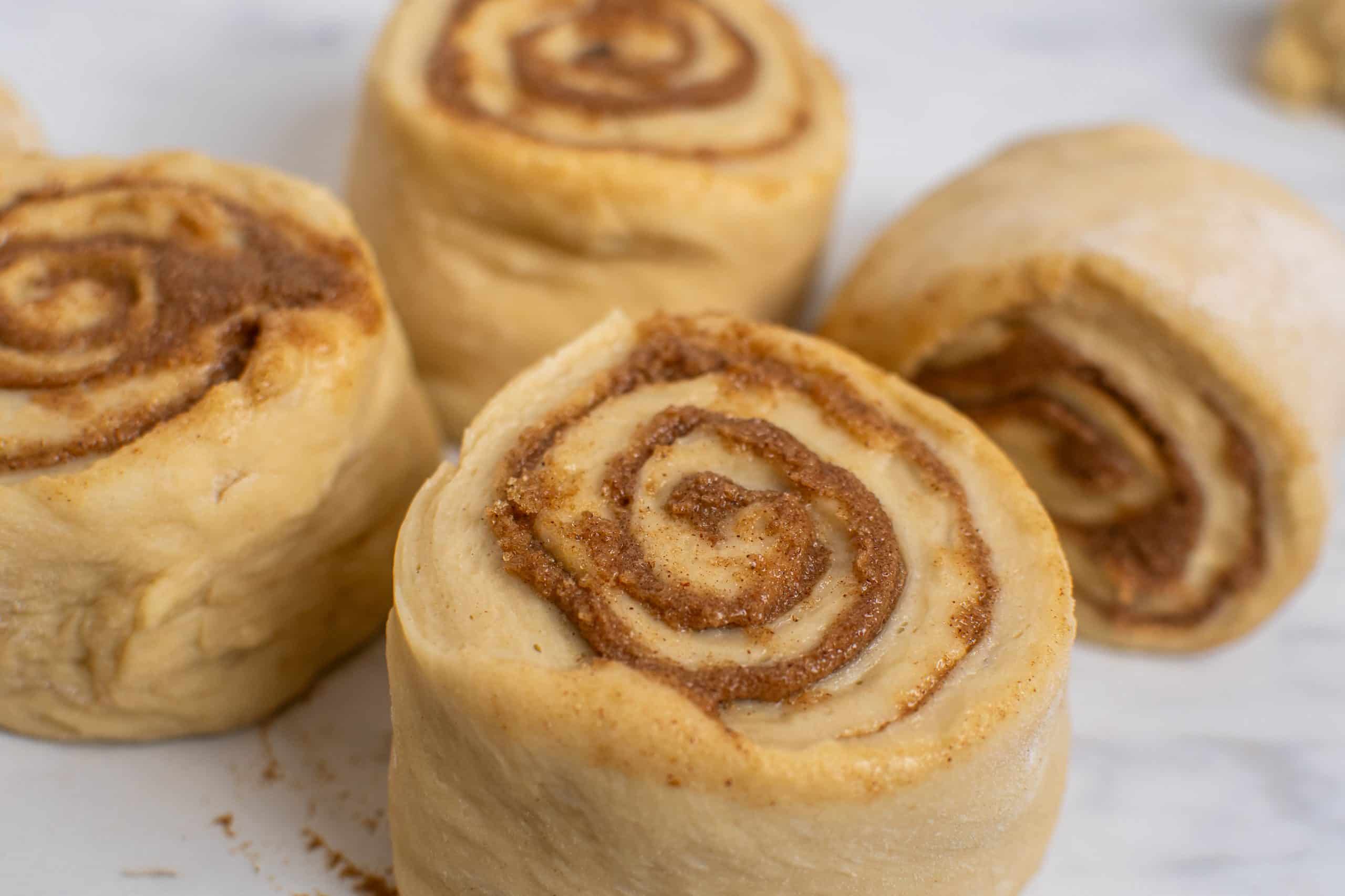 Sliced dough with brown sugar spirals ready to rise.