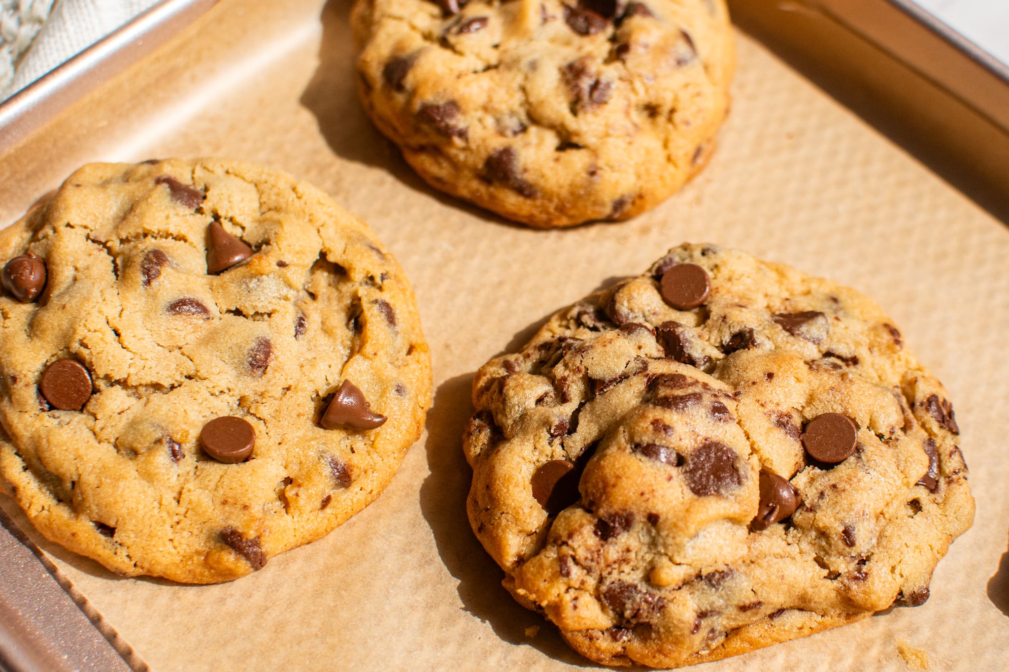 Snoop Dogg peanut butter chocolate chip cookies on parchment paper with melted chocolate chips