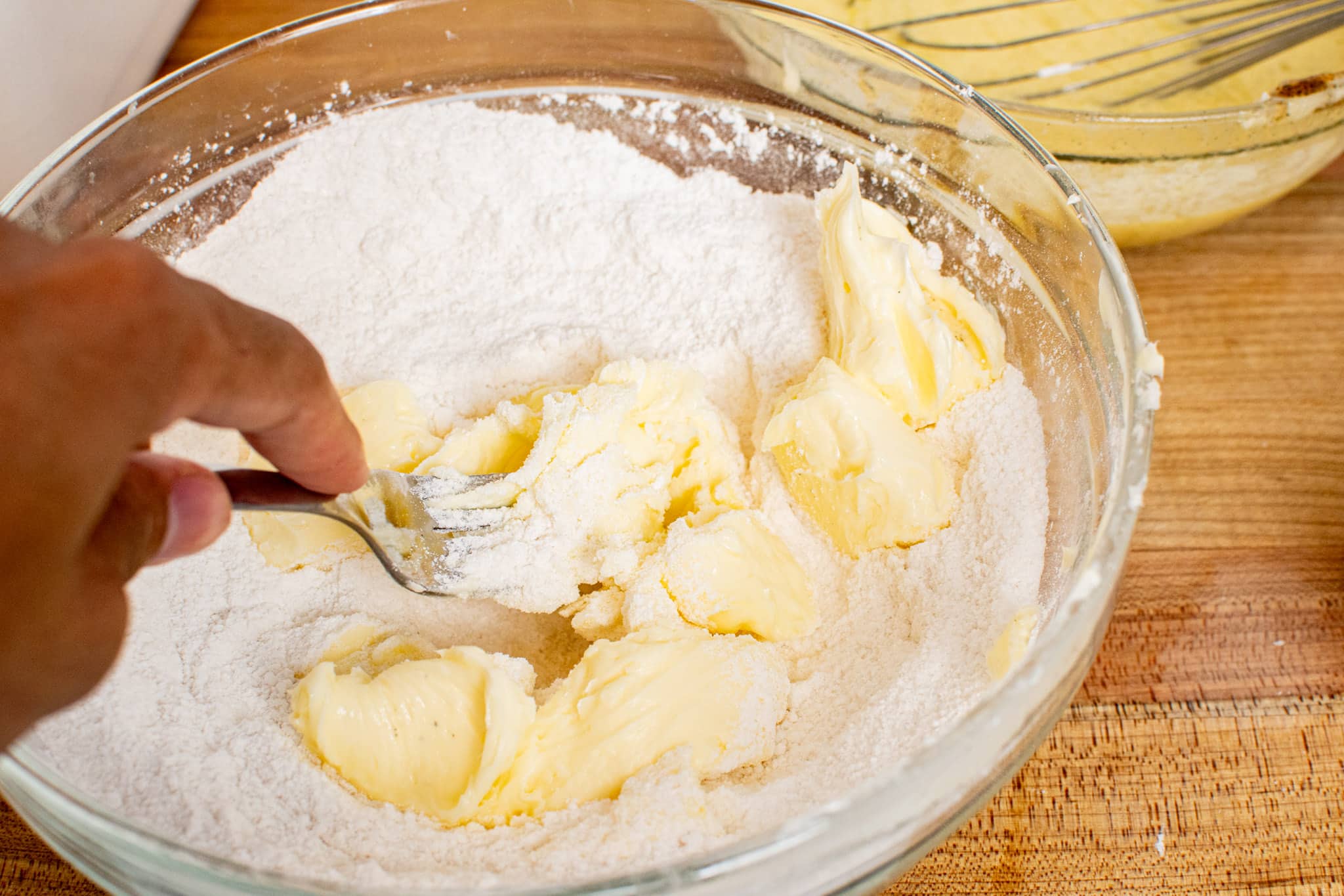 Softened butter added to dry ingredients, creating a crumbly texture.