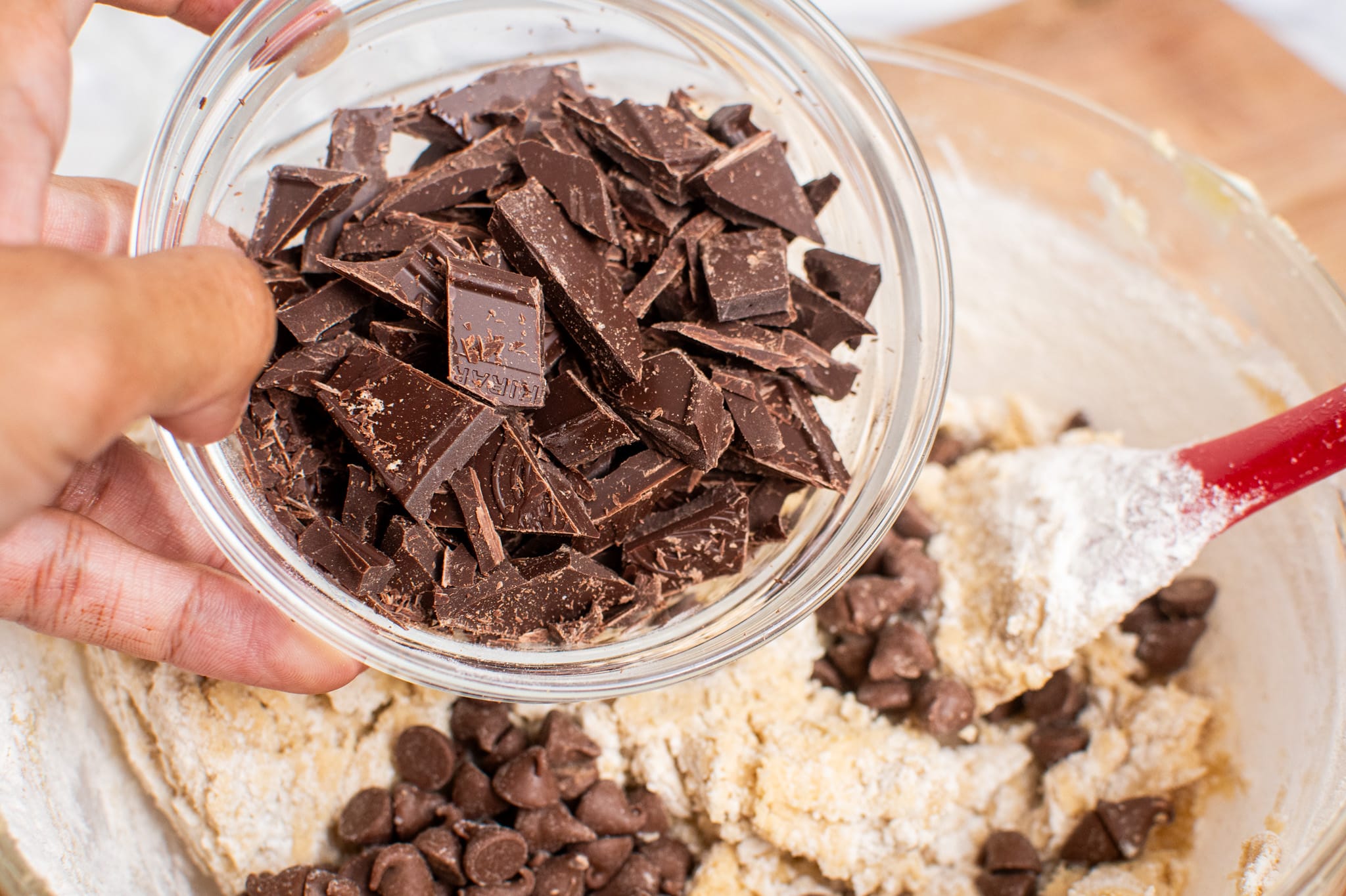 Adding chopped chocolate to the cookie dough.