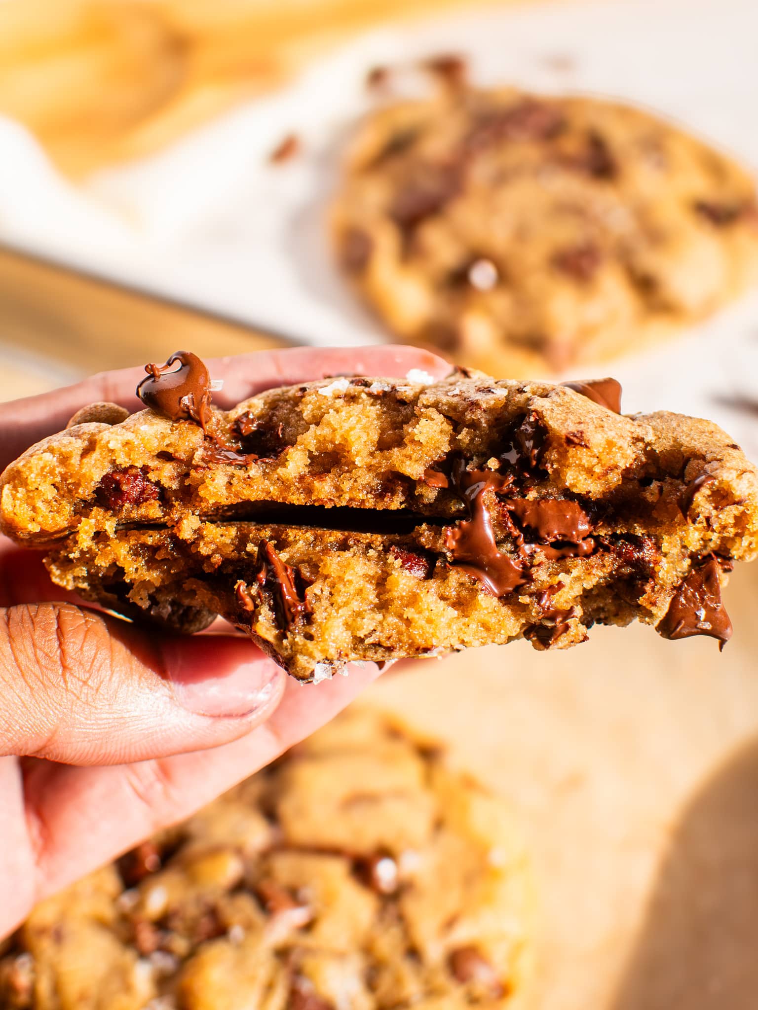 Chewy chocolate chip cookie broken in half showing gooey melted chocolate inside