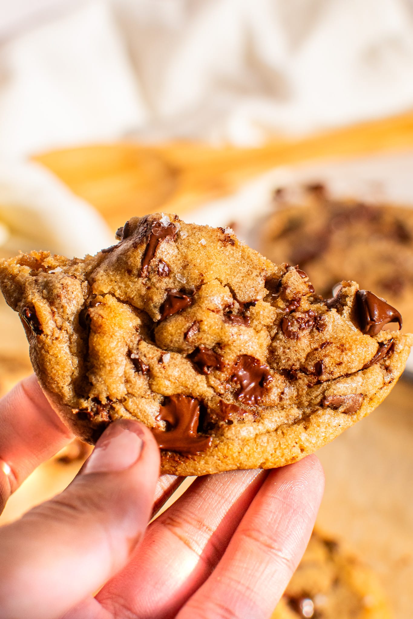Soft and chewy chocolate chip cookie broken in half showing gooey melted chocolate pools