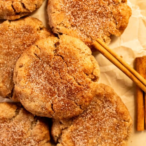 Brown butter snickerdoodle cookies with cinnamon sugar coating on parchment paper