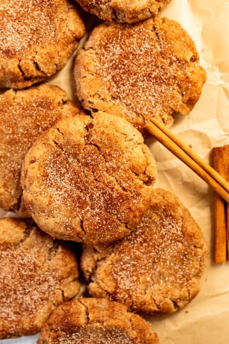 Brown butter snickerdoodle cookies with cinnamon sugar coating on parchment paper