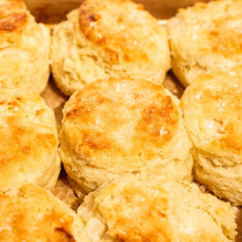 Close up of buttermilk biscuits showing visible flaky layers and golden buttery tops