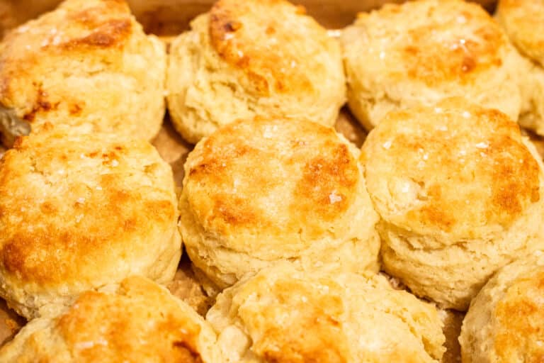 Close up of buttermilk biscuits showing visible flaky layers and golden buttery tops