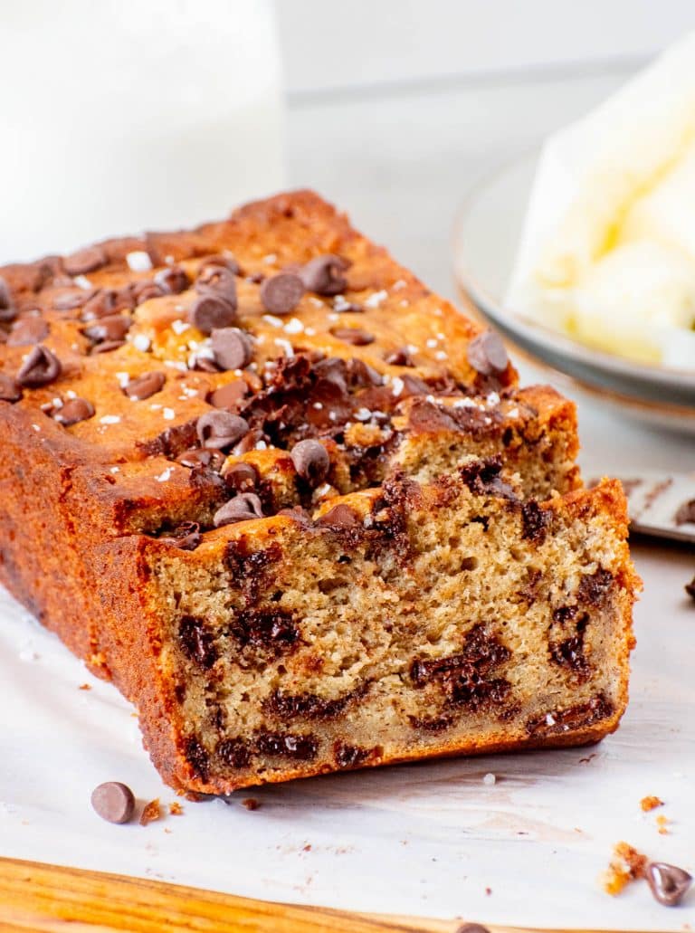 A sliced loaf of moist chocolate chip banana bread with melty chocolate chunks and a golden crust.