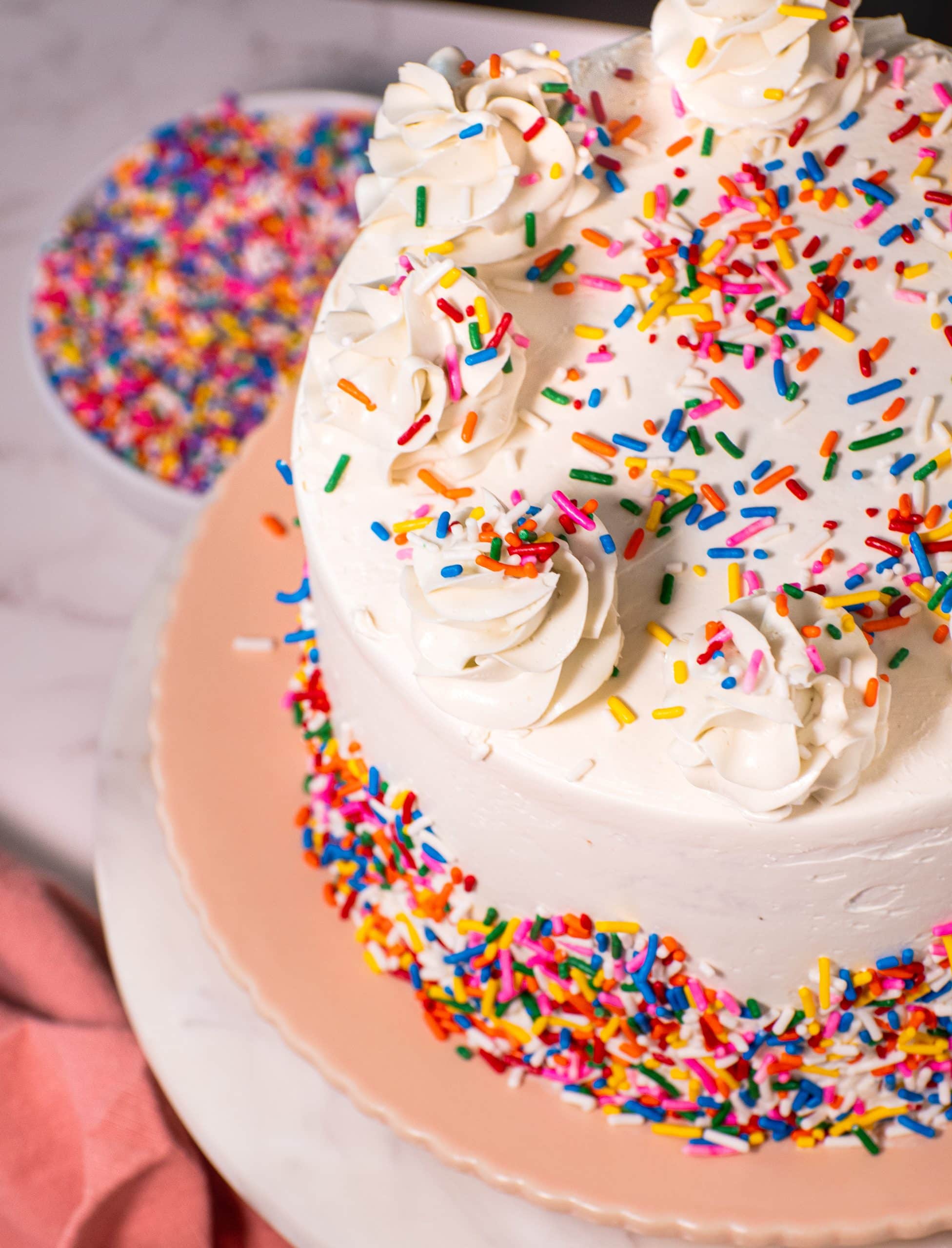 Top view of Funfetti cake with vanilla buttercream swirls and colorful sprinkles.