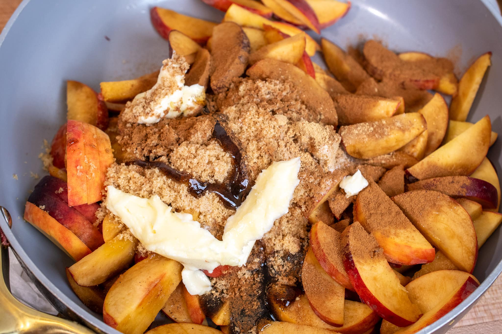 Combining peaches, butter, sugar and spices together in a saucepan.