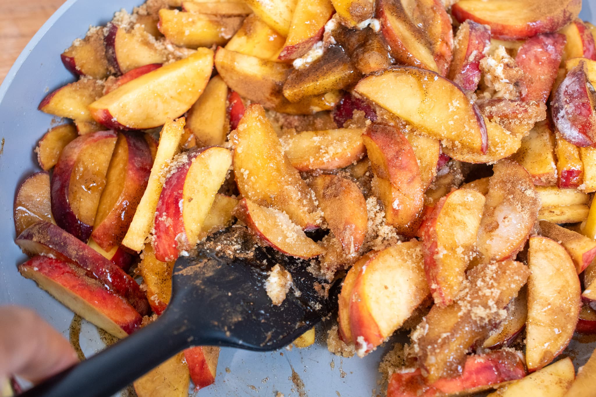 Cooking down peaches and spices together in a saucepan.