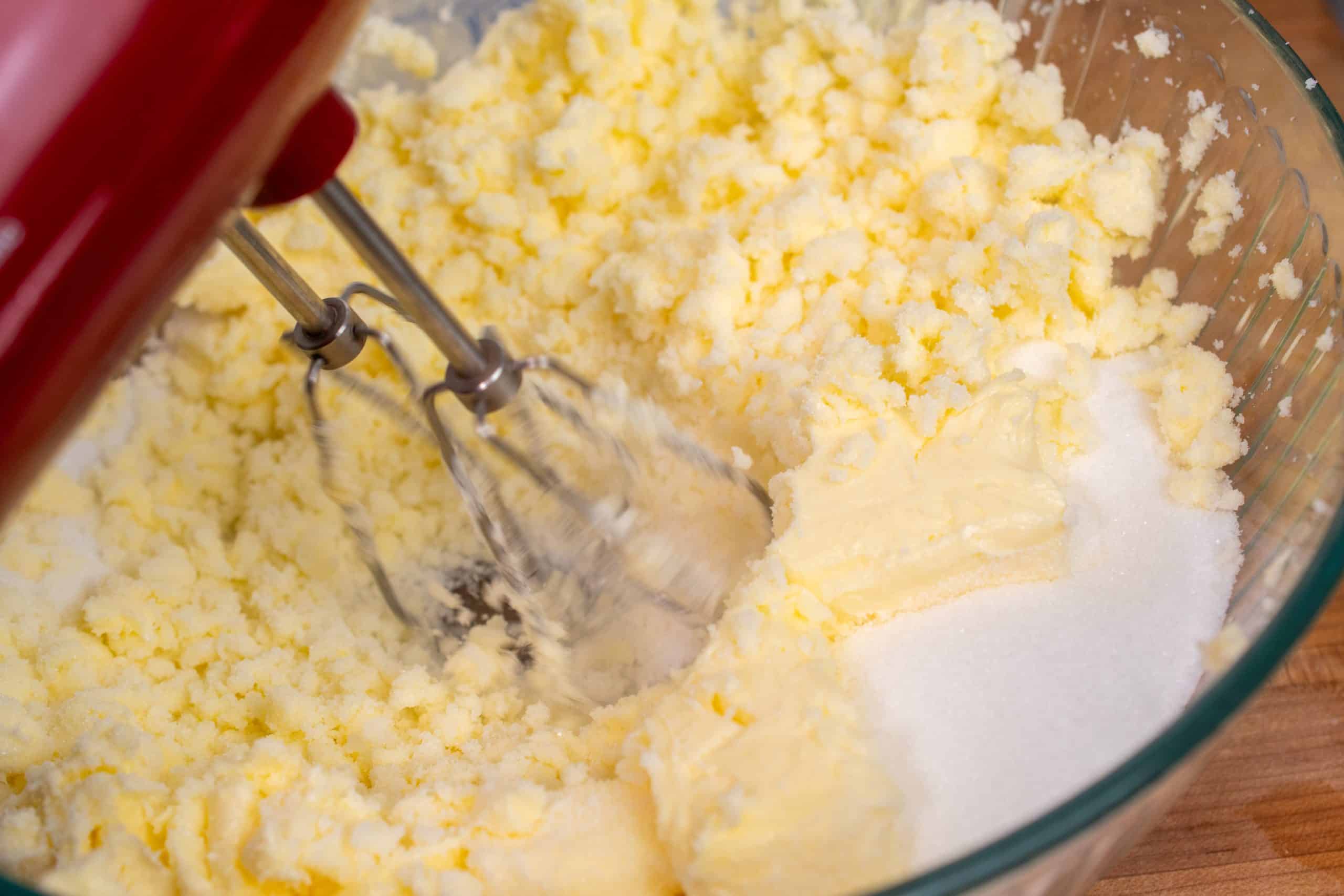 Electric mixer creaming butter and sugar until light and fluffy.
