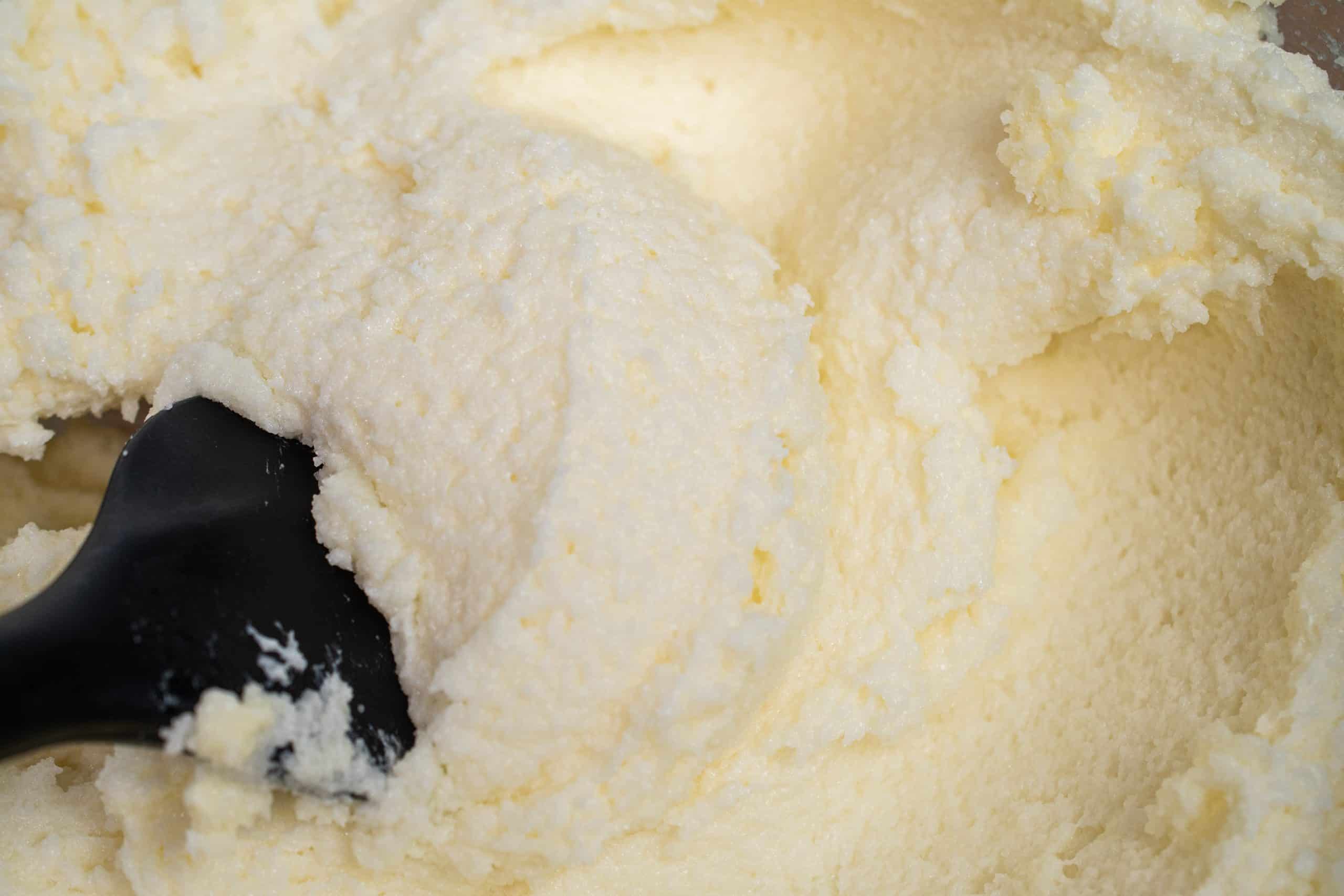 Close-up of creamed butter and sugar mixture, pale and fluffy.
