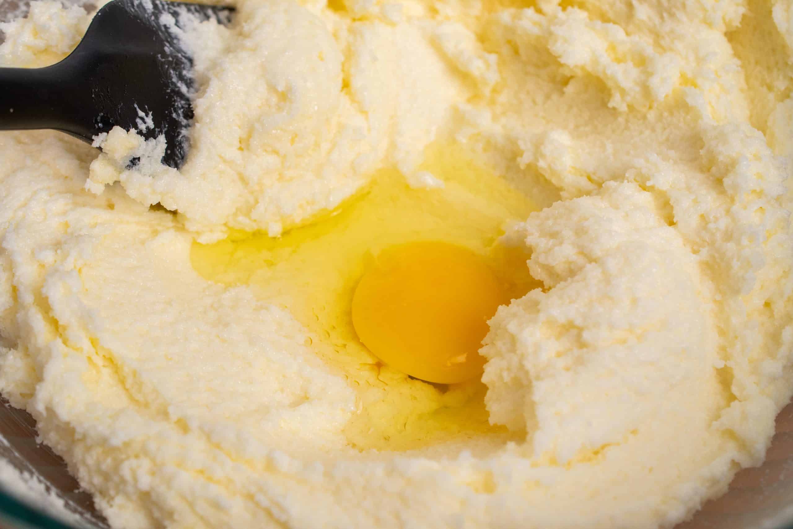 Egg added to creamed butter and sugar mixture, ready for mixing.