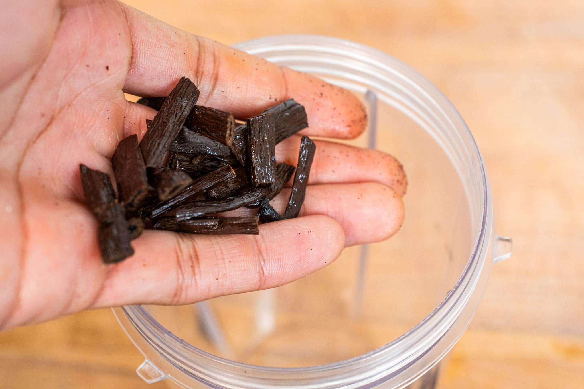 Adding chopped vanilla beans into the blender.
