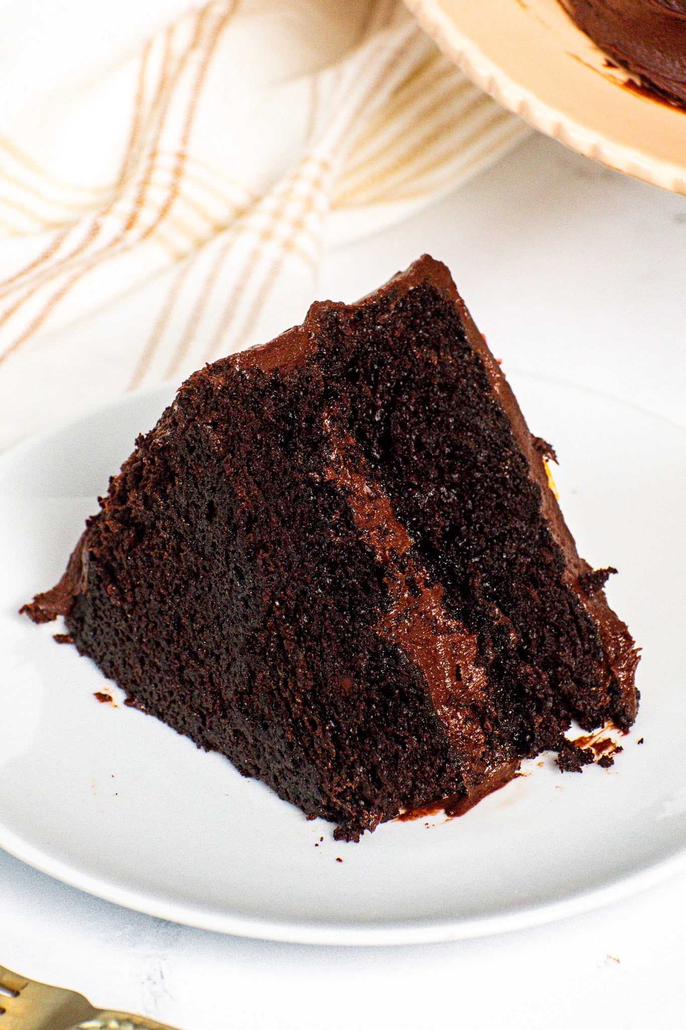 Slice of super moist chocolate cake showing a rich, fudgy crumb