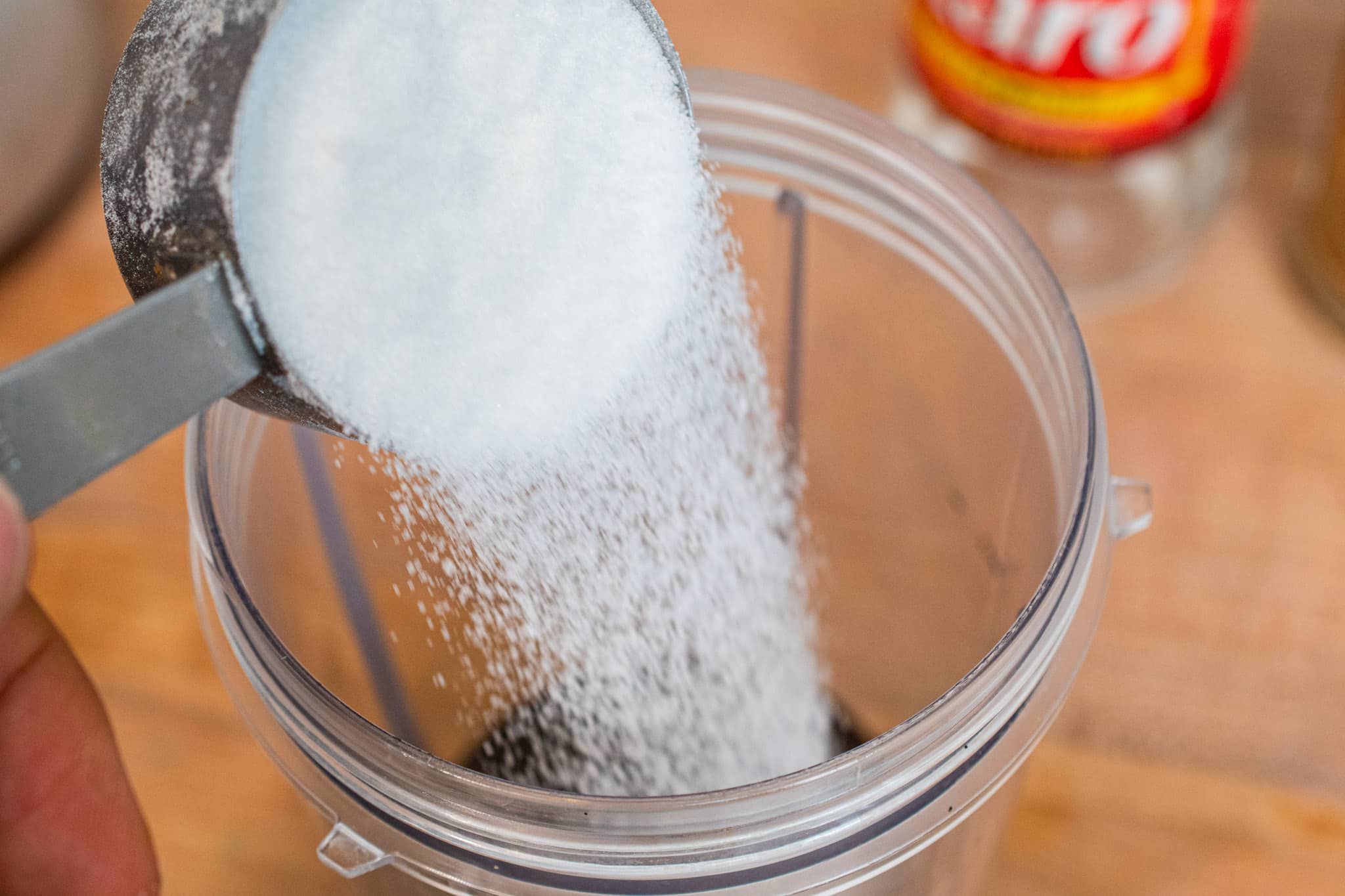 Adding granulted white sugar into the blender.
