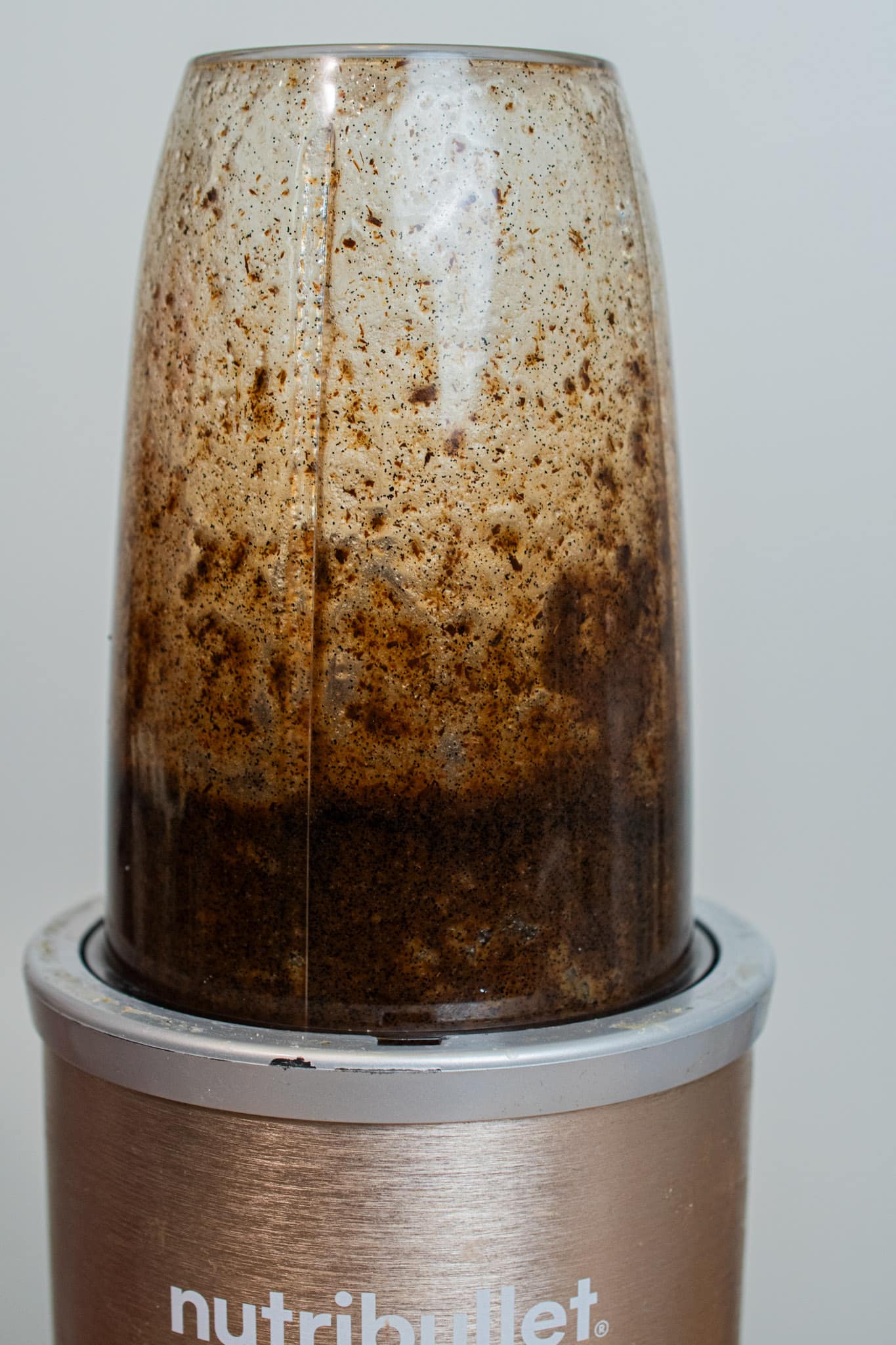 Blending vanilla beans, sugar, and alcohol until a paste is created.