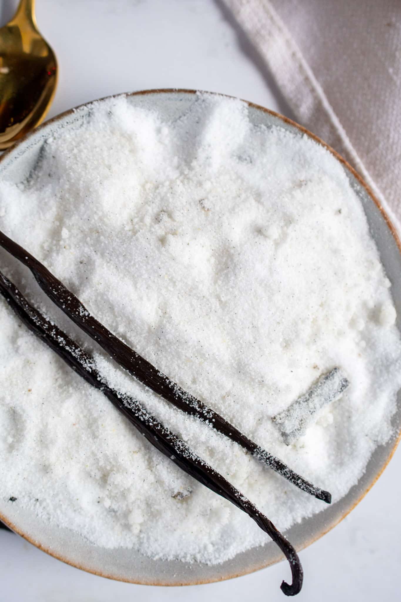 Bowl of homemade vanilla sugar with vanilla beans on top