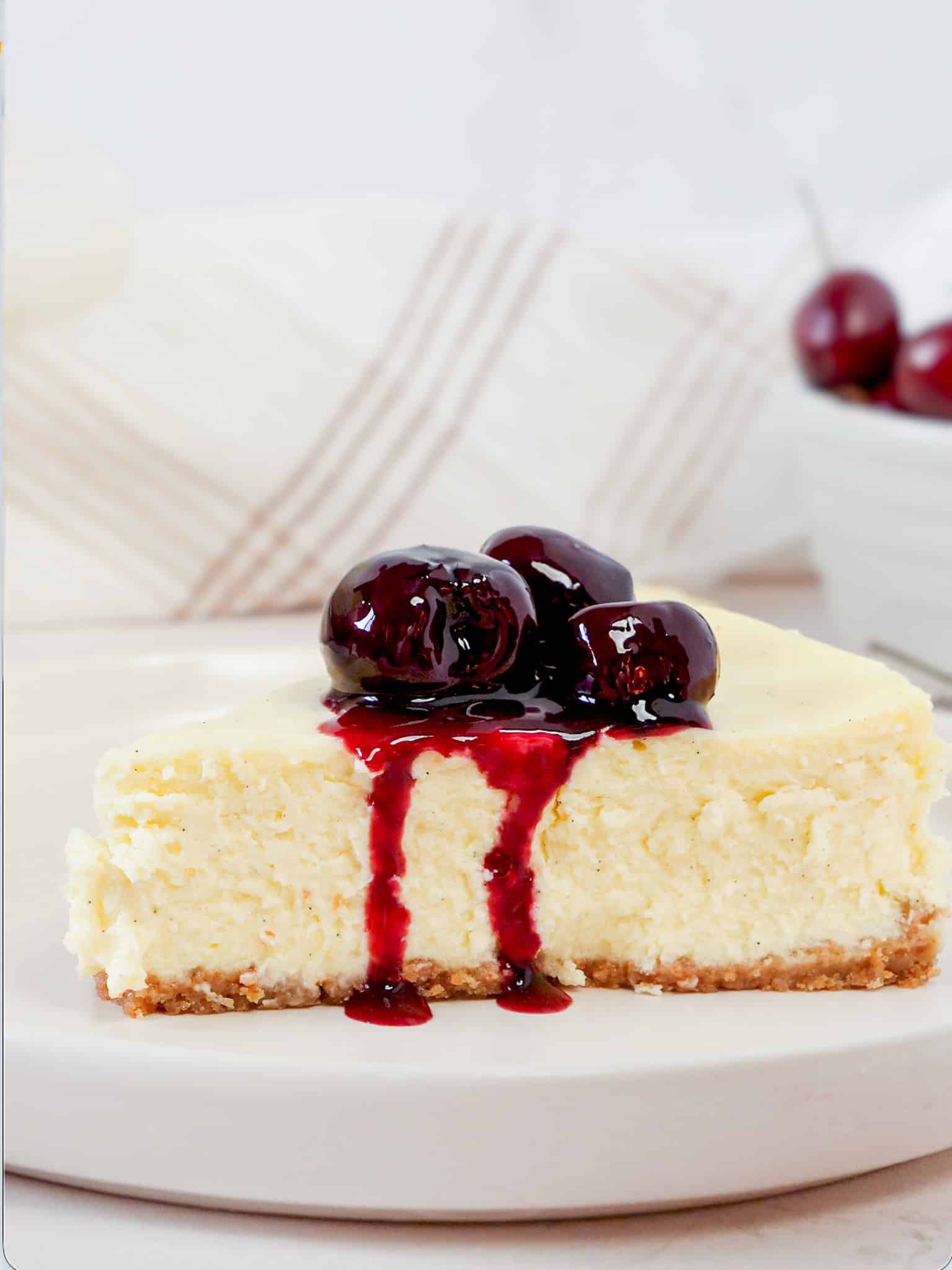 slice of cherry cheesecake with vanilla bean filling and homemade cherry compote on top