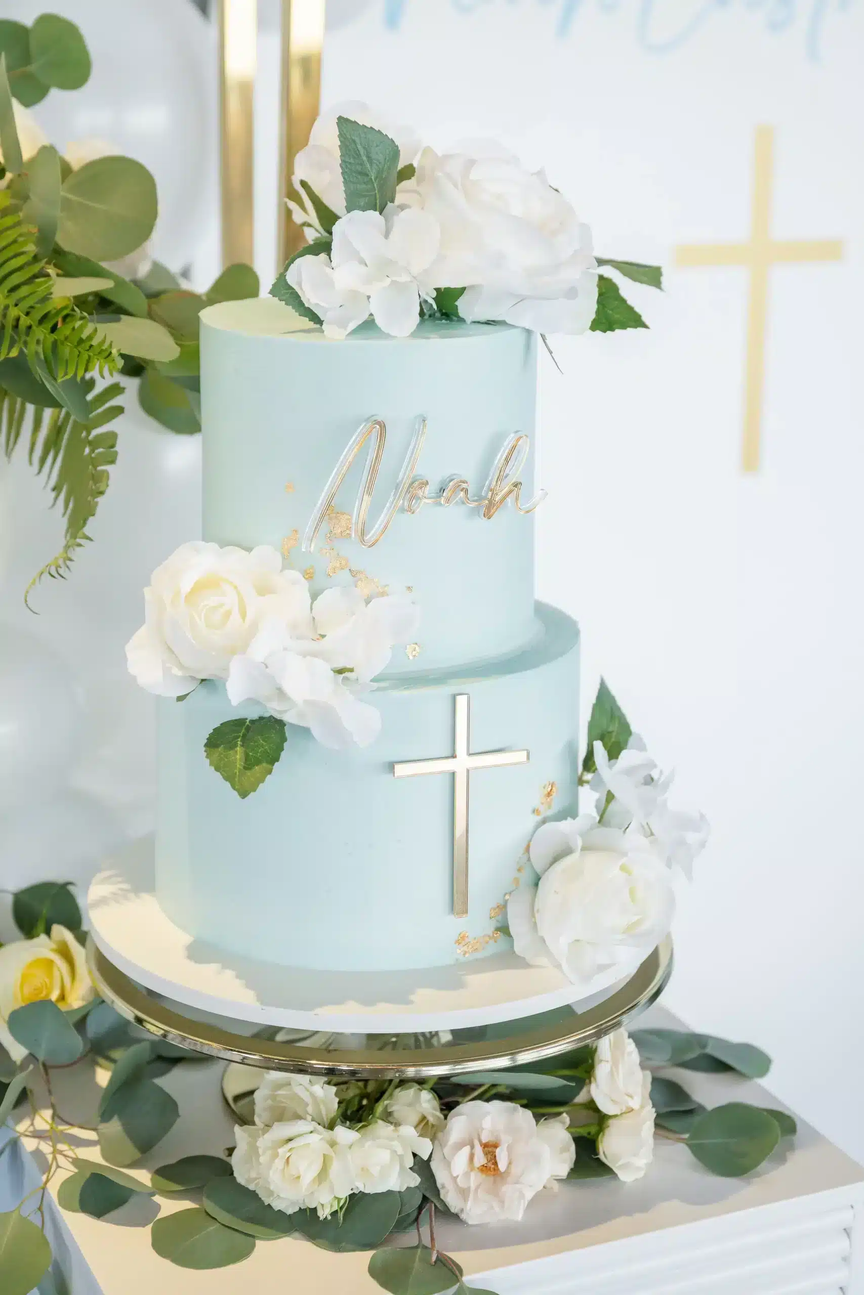 Elegant blue and gold wedding cake with cascading flowers and gold accents, perfect for weddings or formal events.