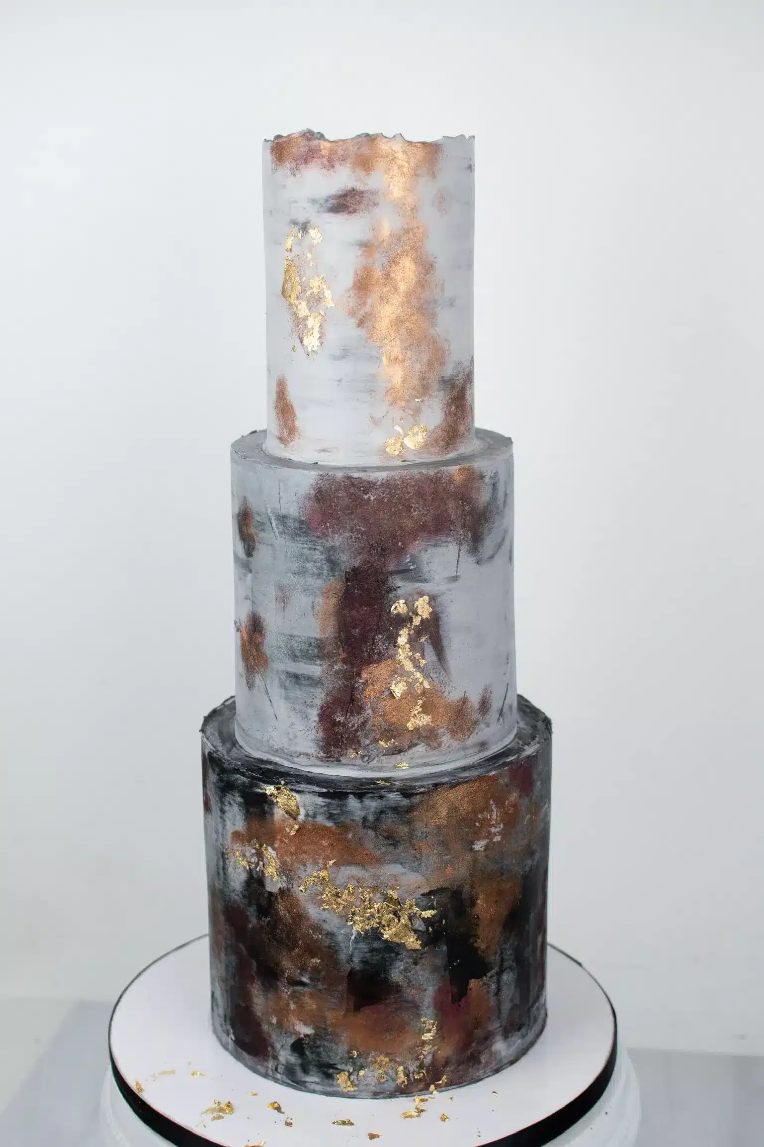 Industrial-themed wedding cake with copper, gold, and silver accents, ideal for modern weddings.