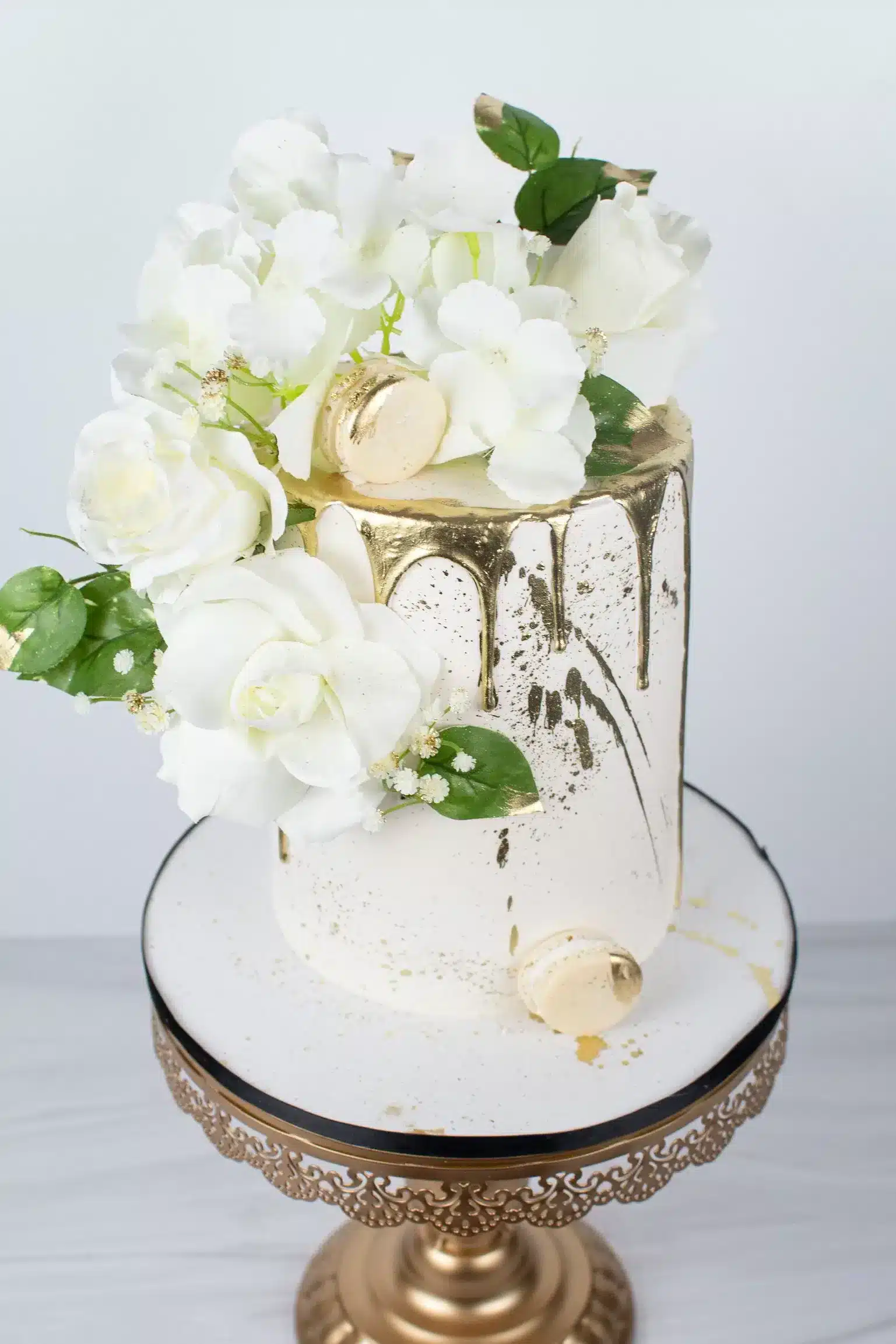 White cake with fresh white flowers and greenery, perfect for weddings, bridal showers, or elegant celebrations.