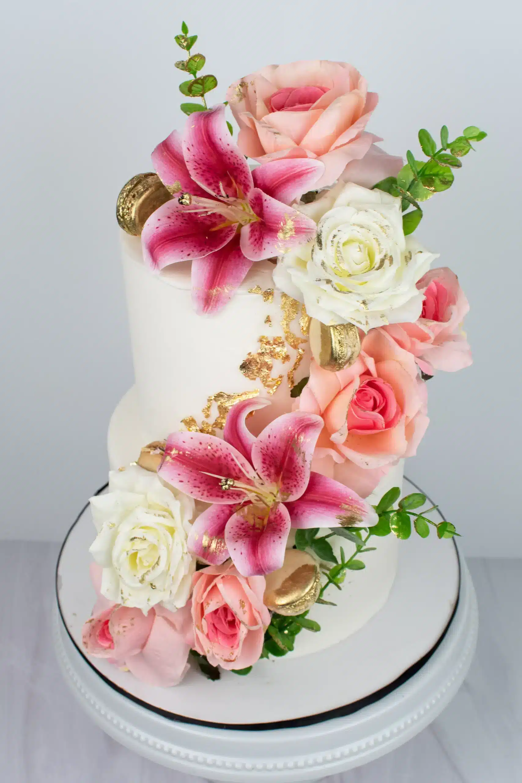 Wedding cake with cascading pink and white roses, ideal for romantic celebrations or weddings.