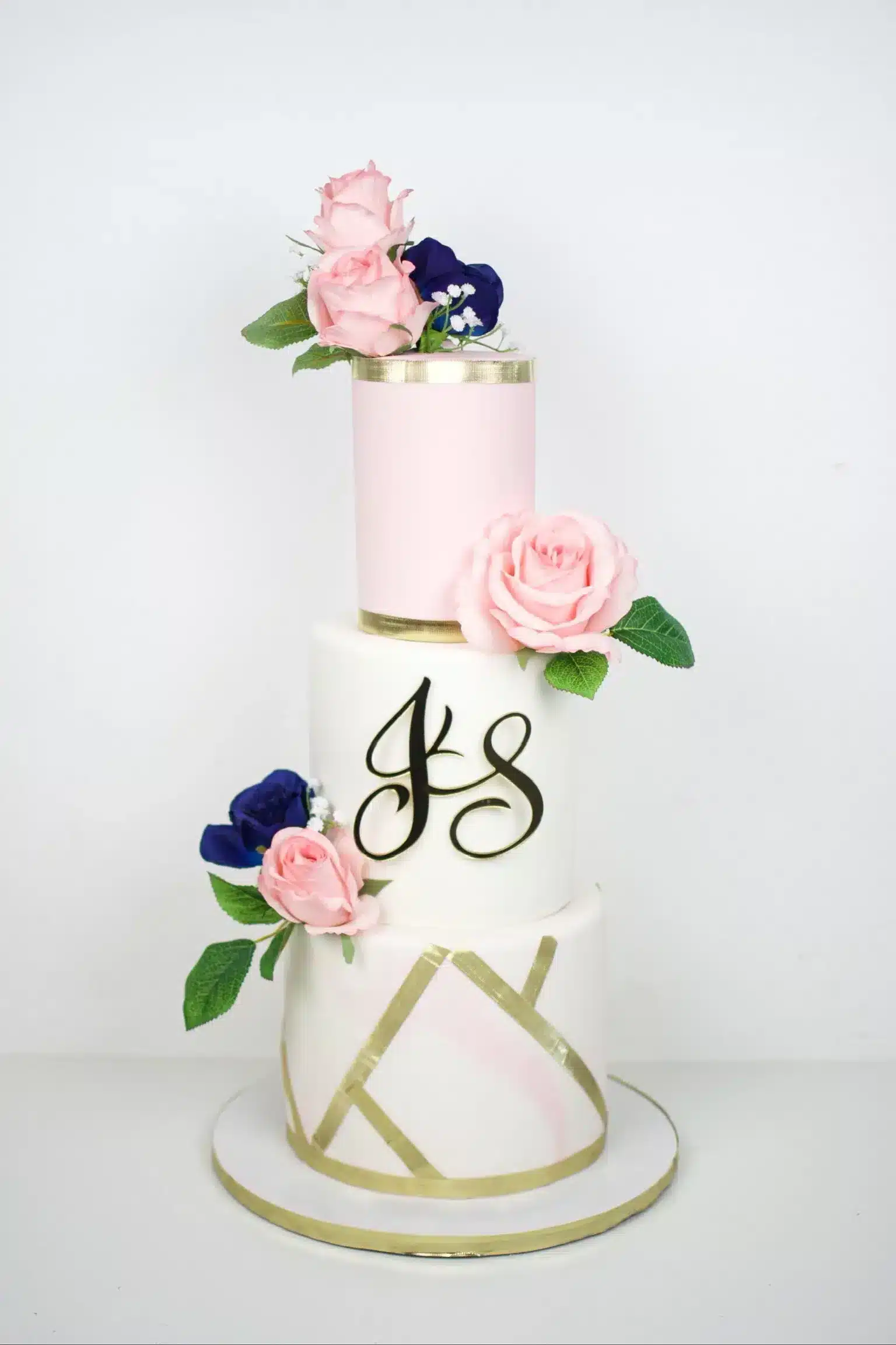 Monogram wedding cake with floral accents in pink and purple, ideal for intimate weddings or engagements.