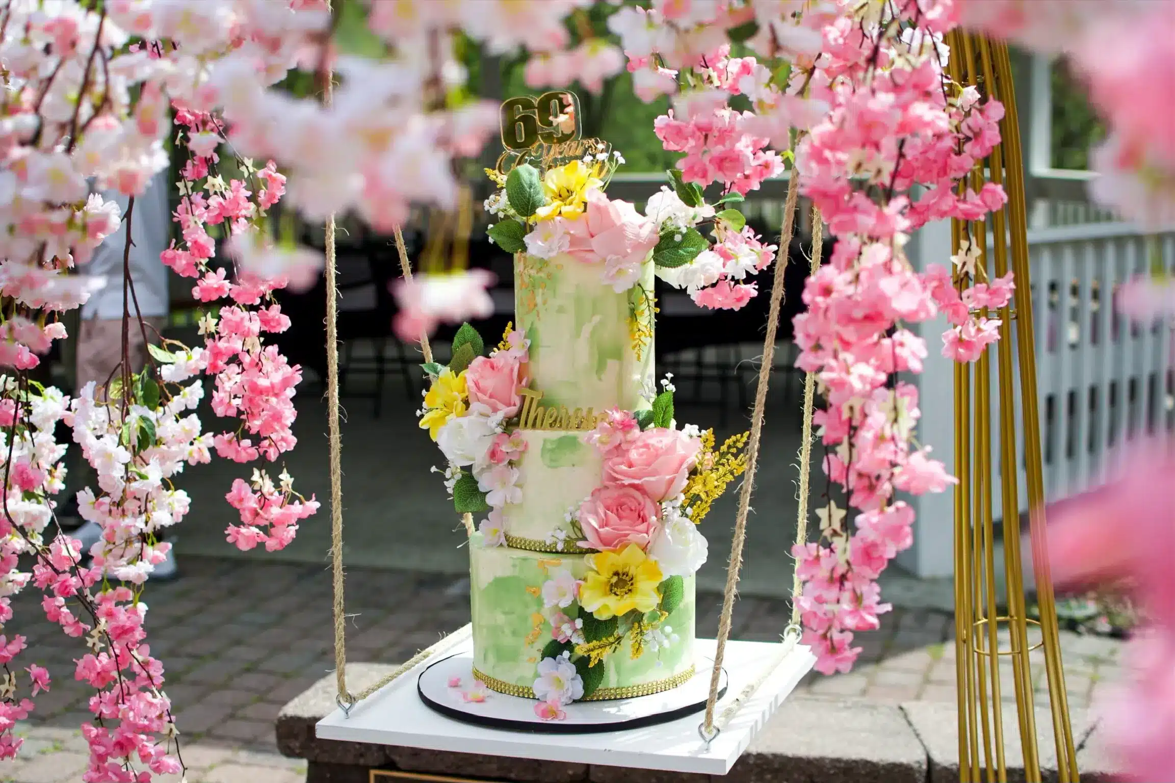 Pastel cake with cascading floral arrangement, perfect for garden parties or spring weddings.
