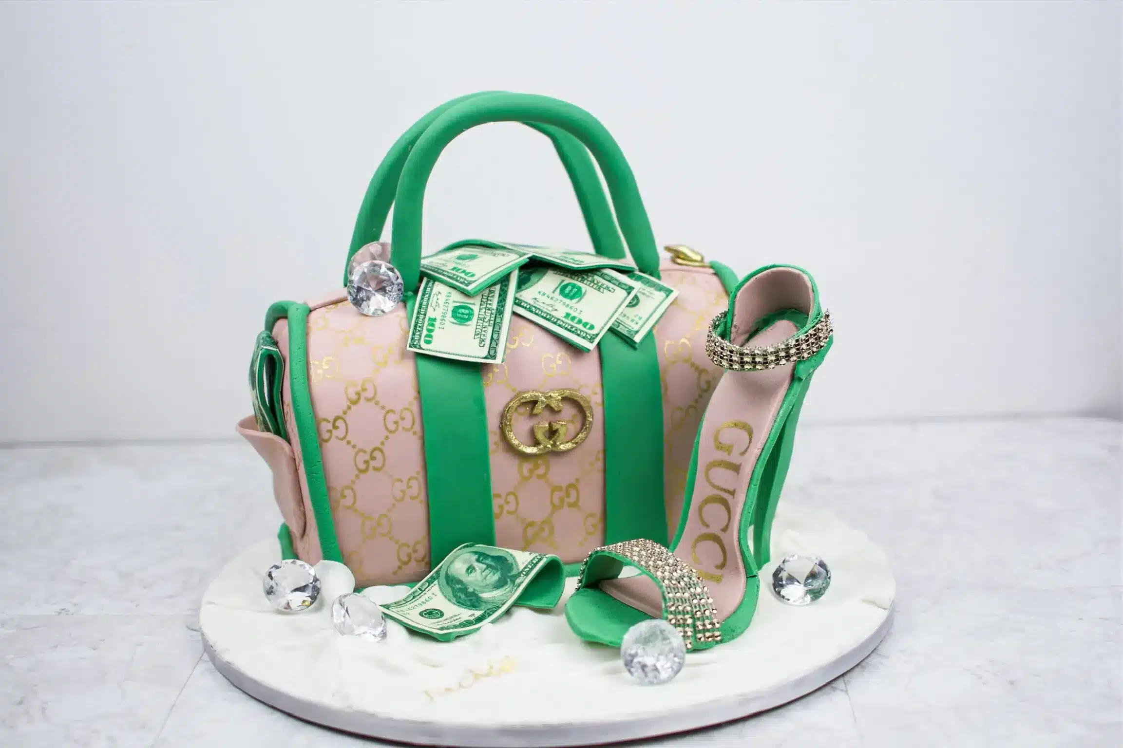 Green handbag cake with edible designer details and GG monogram, perfect for fashion-themed celebrations.
