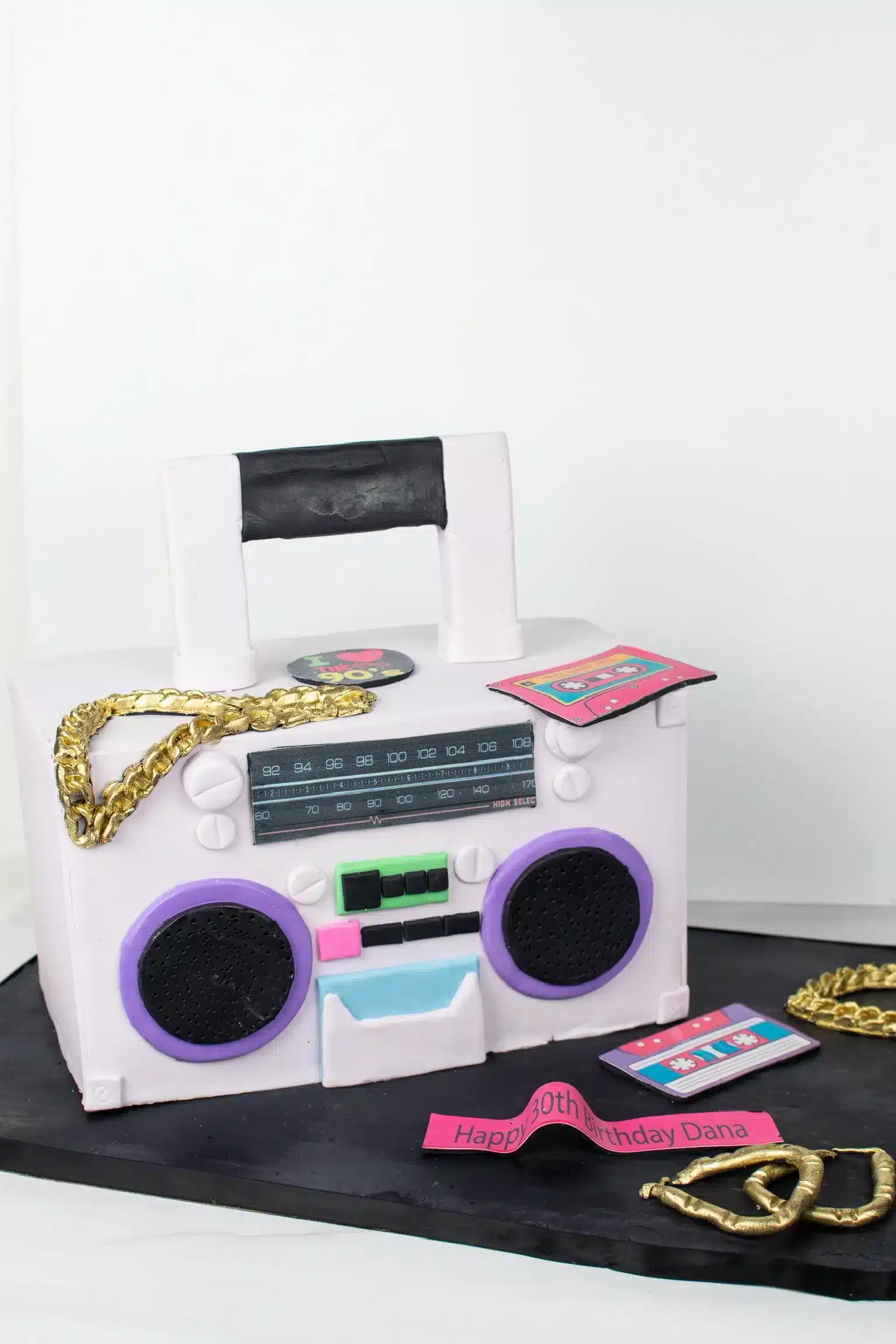 Boom box cake with music-themed fondant decorations, ideal for music lovers.