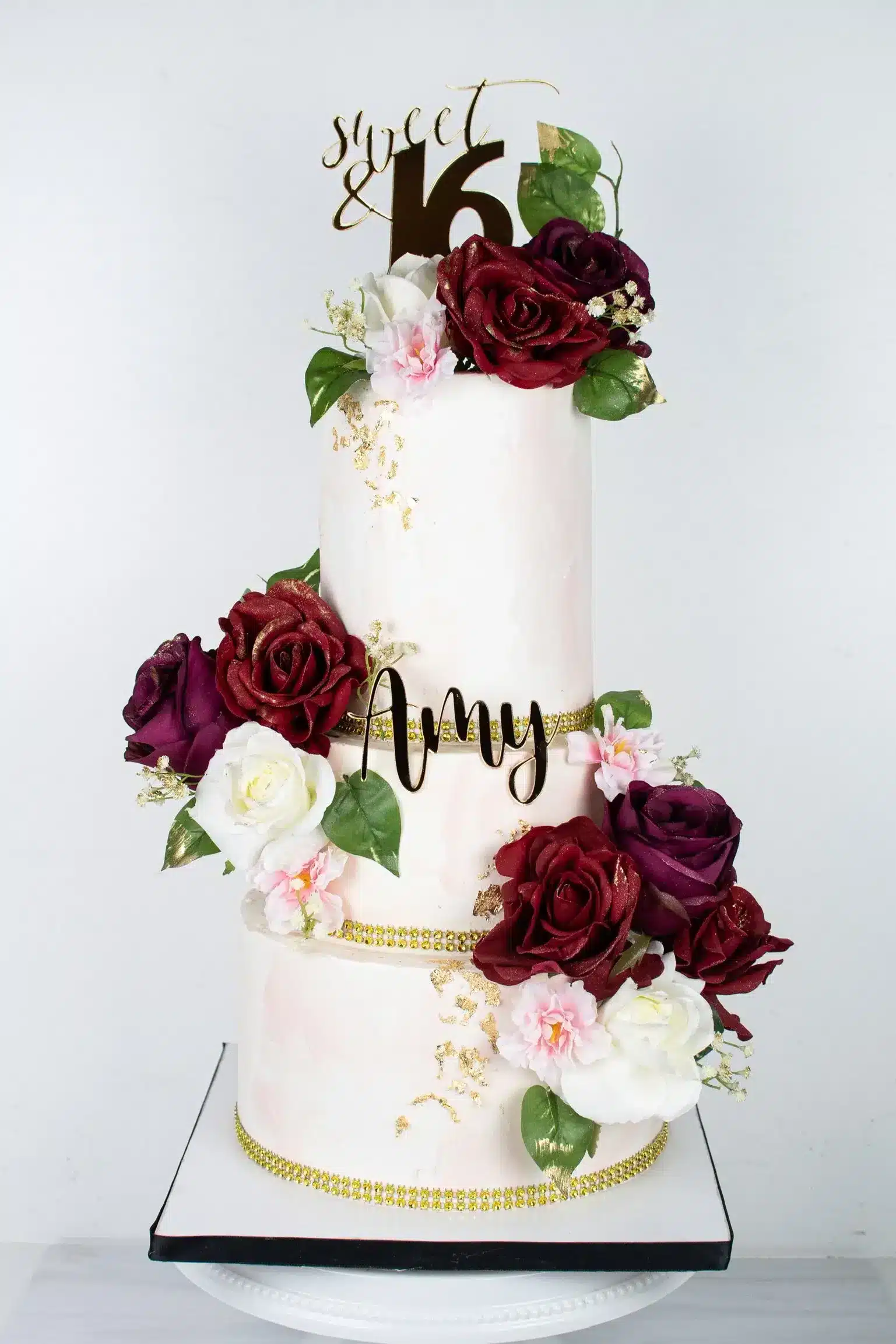 Tiered white buttercream cake with soft pink gradient and floral decoration.